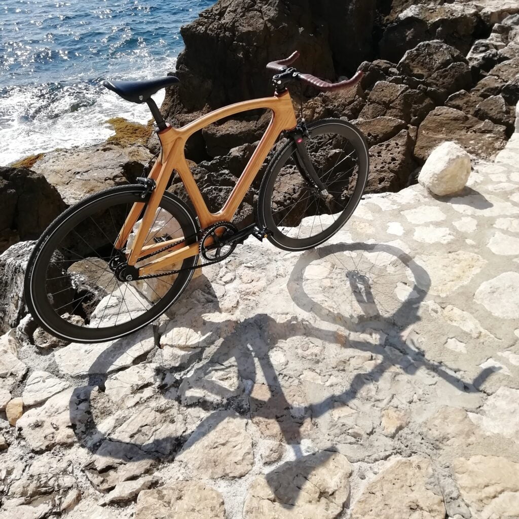 Vélo cadre ref001 numéro 003 au bord de la mer sur chemin. Ombre sur le sol.